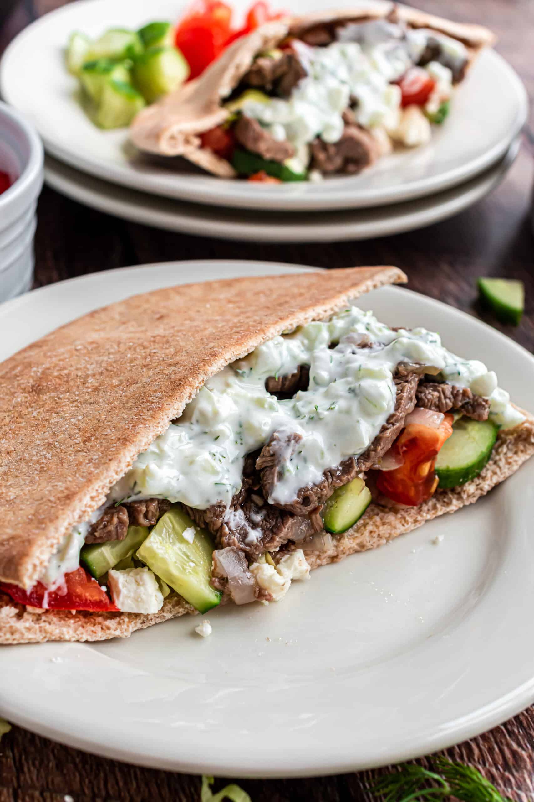 Dinner plate with whole wheat pita, beef gyros, and tzatziki sauce.