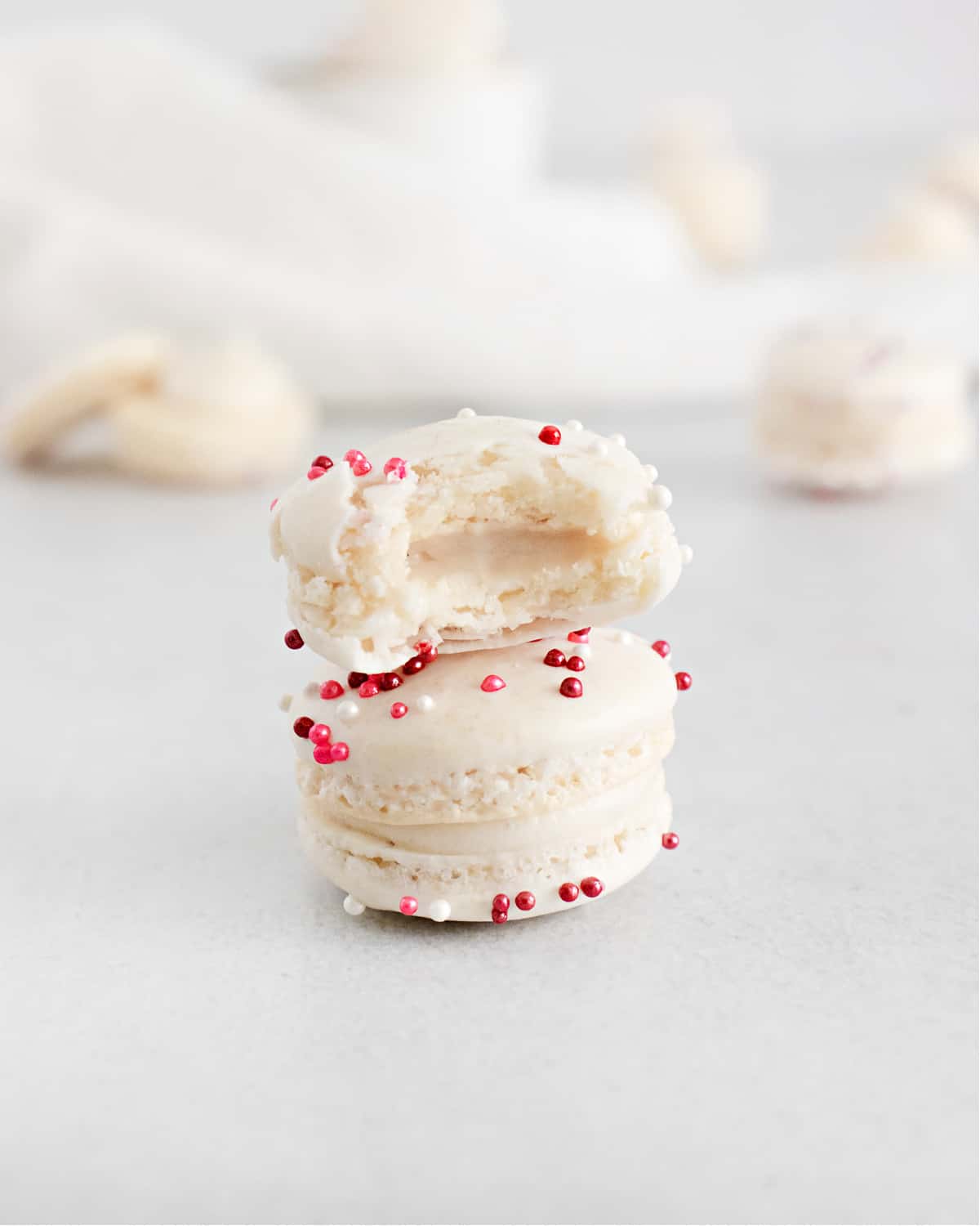 Vanilla macarons stacked with bite removed.