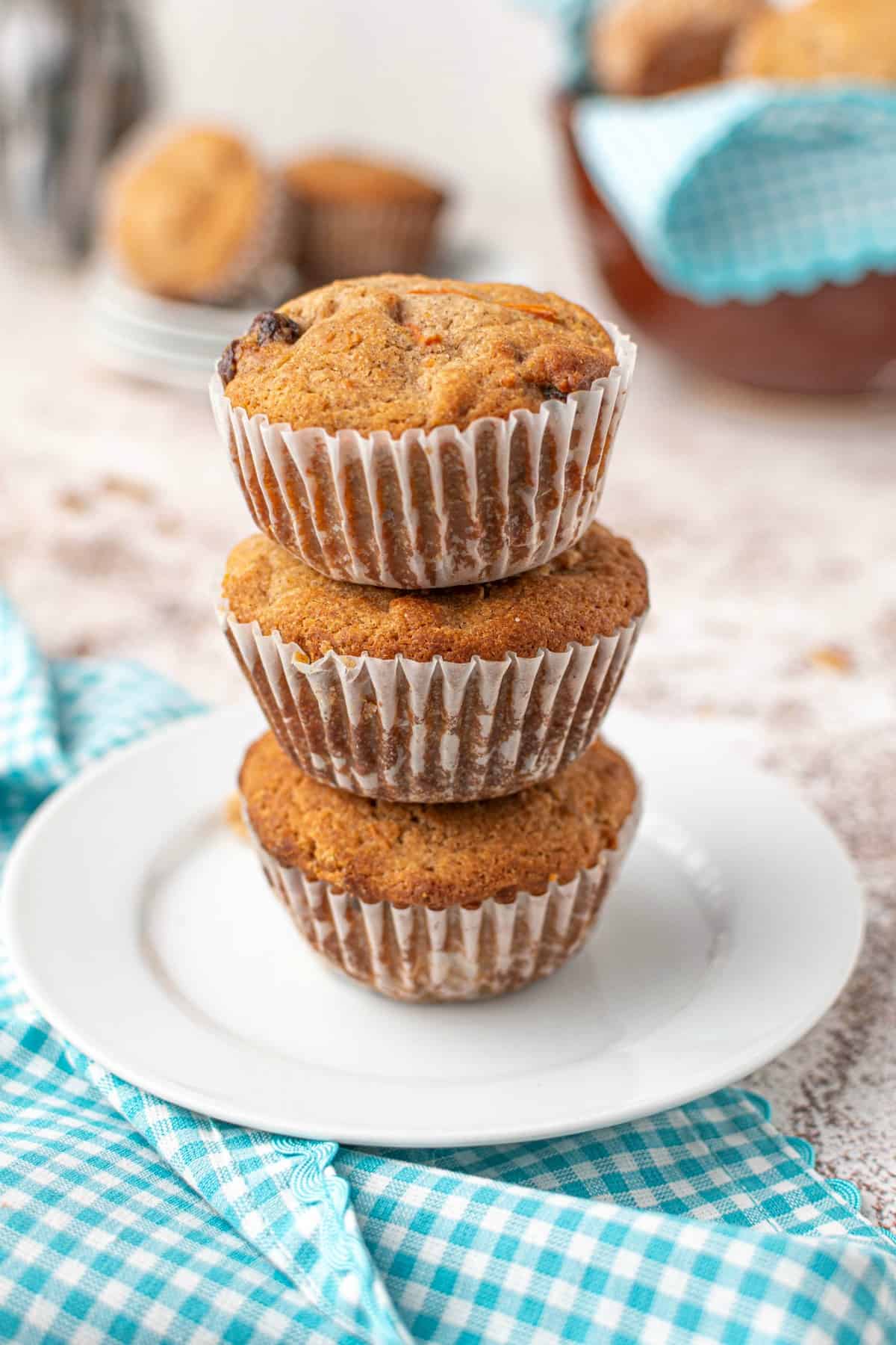 Stack of three morning glory muffins on a white plate.