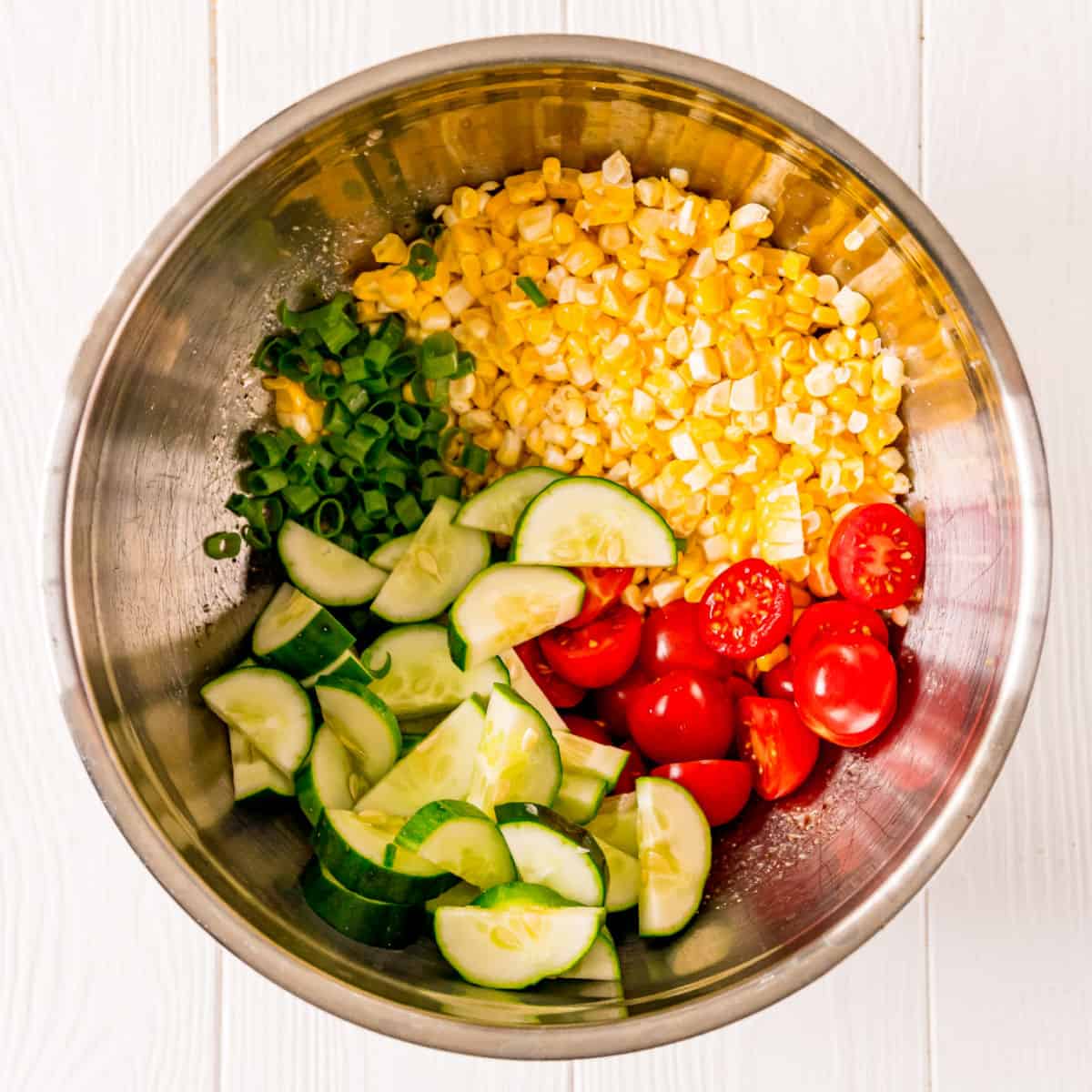 Ingredients needed for orzo pasta salad in mixing bowl.