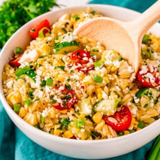 This light and easy Orzo Pasta Salad recipe is tossed with a delicious lemon honey dressing and loaded with fresh corn, cherry tomatoes, cucumbers, and scallions. Feta cheese and a sprinkle of fresh herbs make this side dish complete!