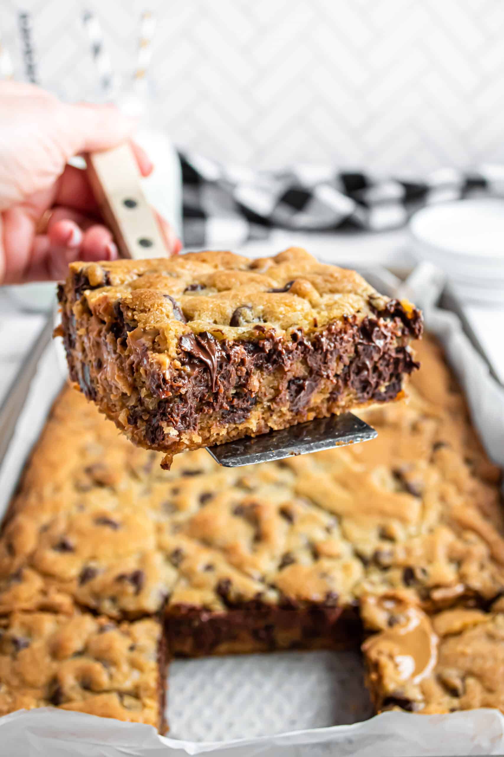 Slice of peanut butter chocolate chip bars being lifted on a spatula.