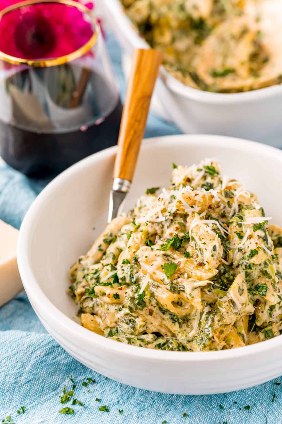 Spinach alfredo pasta served in a bowl.