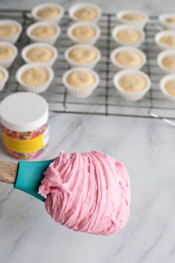 Pink buttercream frosting on a spatula.