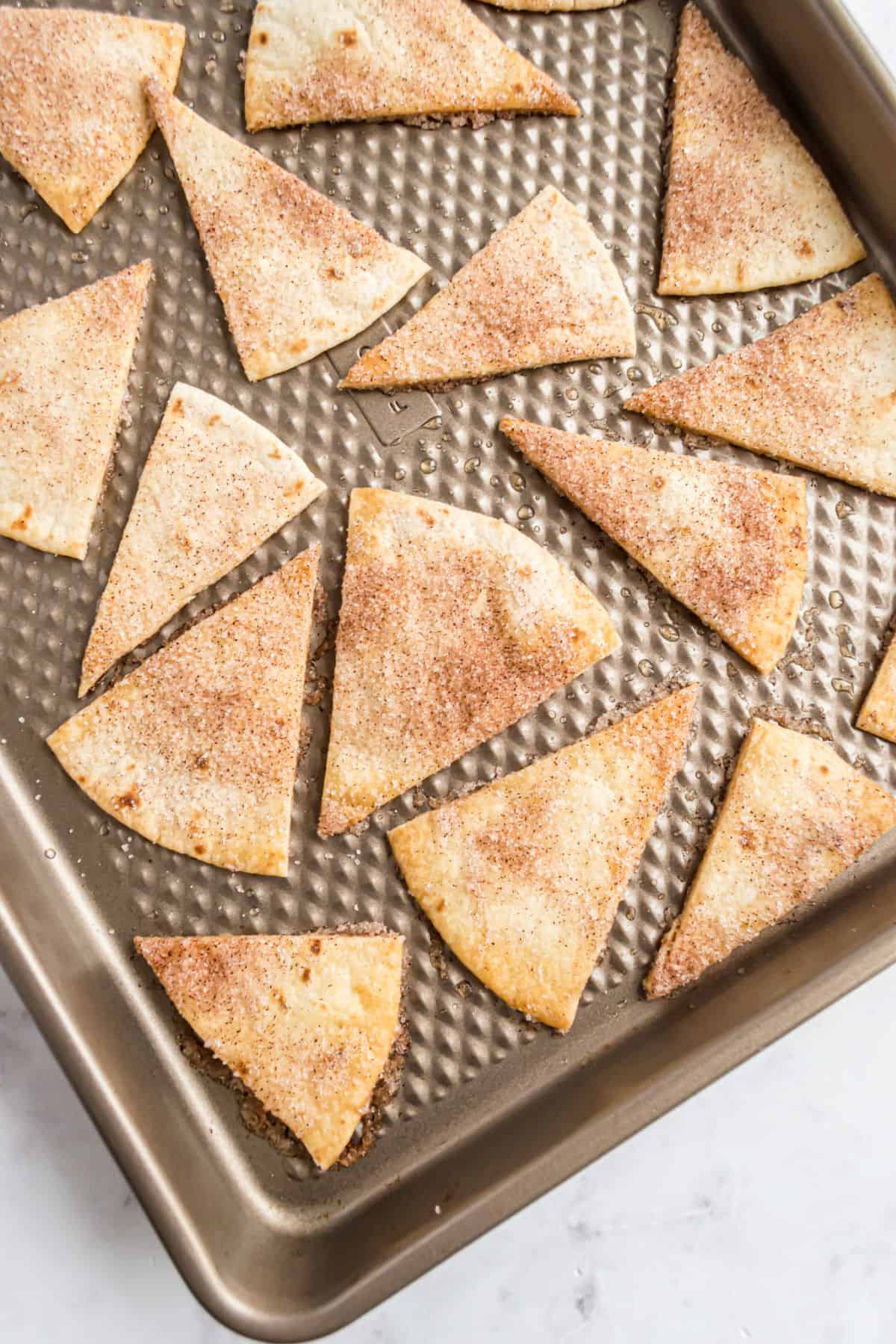 Cinnamon tortilla chips on a baking sheet.