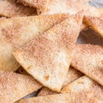 Stack of baked cinnamon tortilla chips in a bowl.