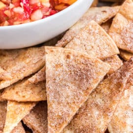 Baked cinnamon chips in a bowl with a side of fruit salsa for dipping.