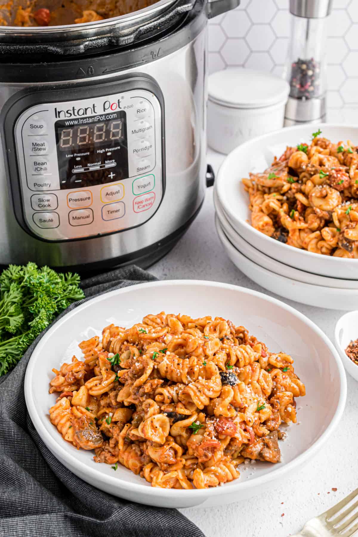 Pizza pasta in a bowl with instant pot in background.