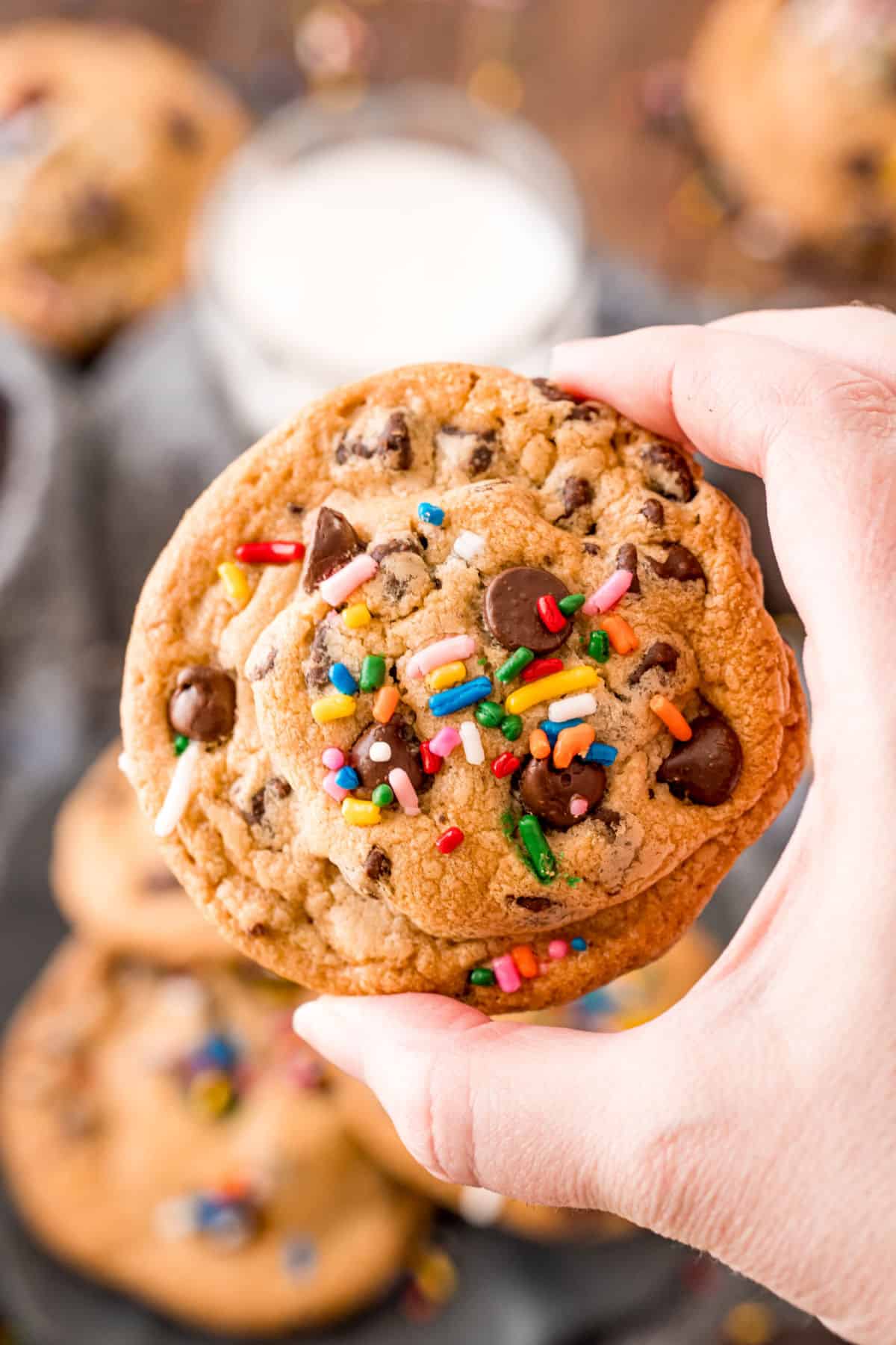 Oreo stuffed cookie with sprinkles being held up in a hand,