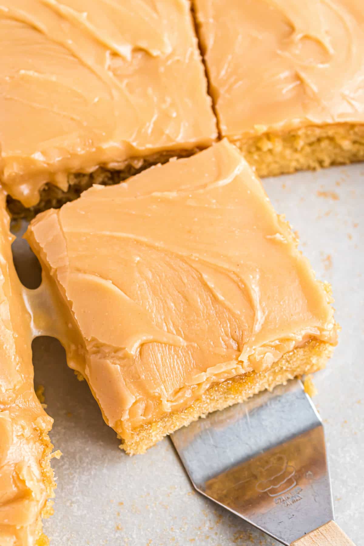 Peanut butter sheet cake square on a spatula for serving.