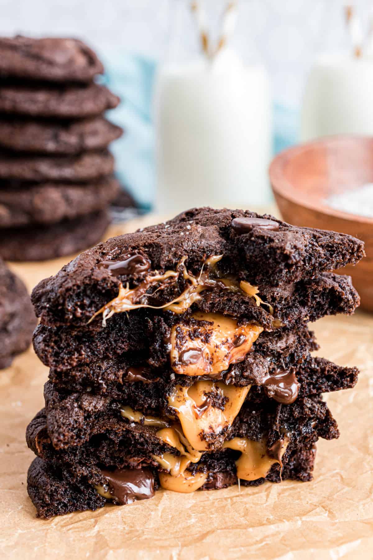 Stack of chocolate cookies cut in half and caramel running down the middle.