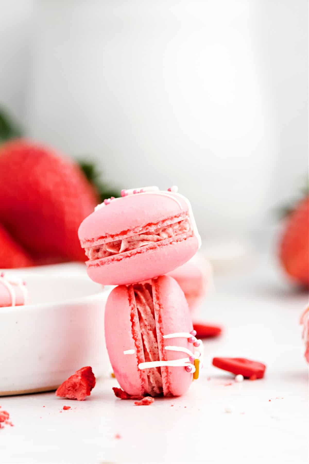 Two strawberry macarons stacked on top of eachother.
