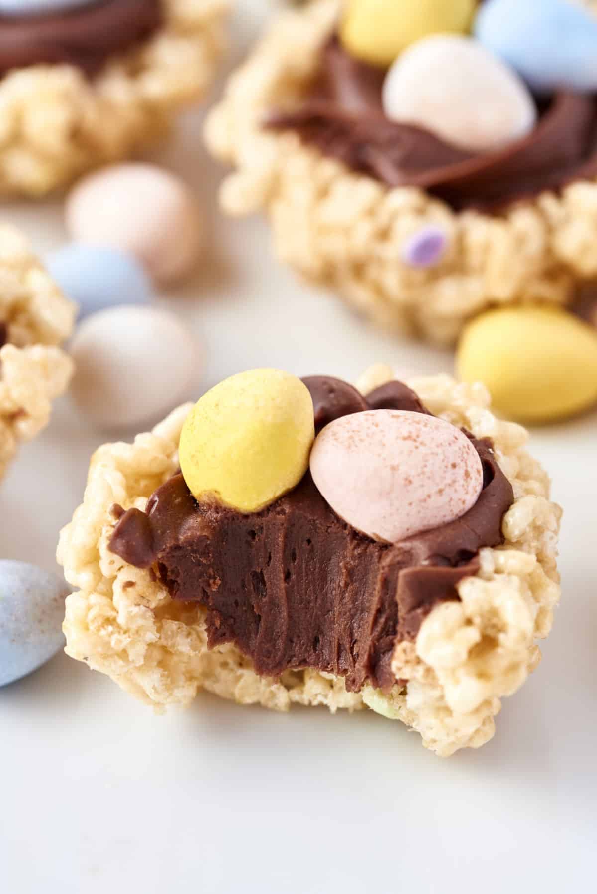Rice krispie treat shaped as a nest and garnished with chocolate frostin and candy. 