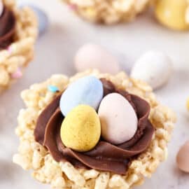 Rice krispie treats shaped as a nest and filled with chocolate frosting and candy.