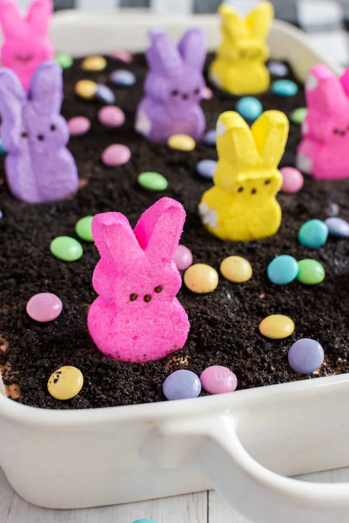 Easter dirt pudding cake topped with pasted M&M's and PEEPS marshmallows.