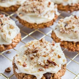 Cream cheese frosted carrot cake cookies on wire rack.