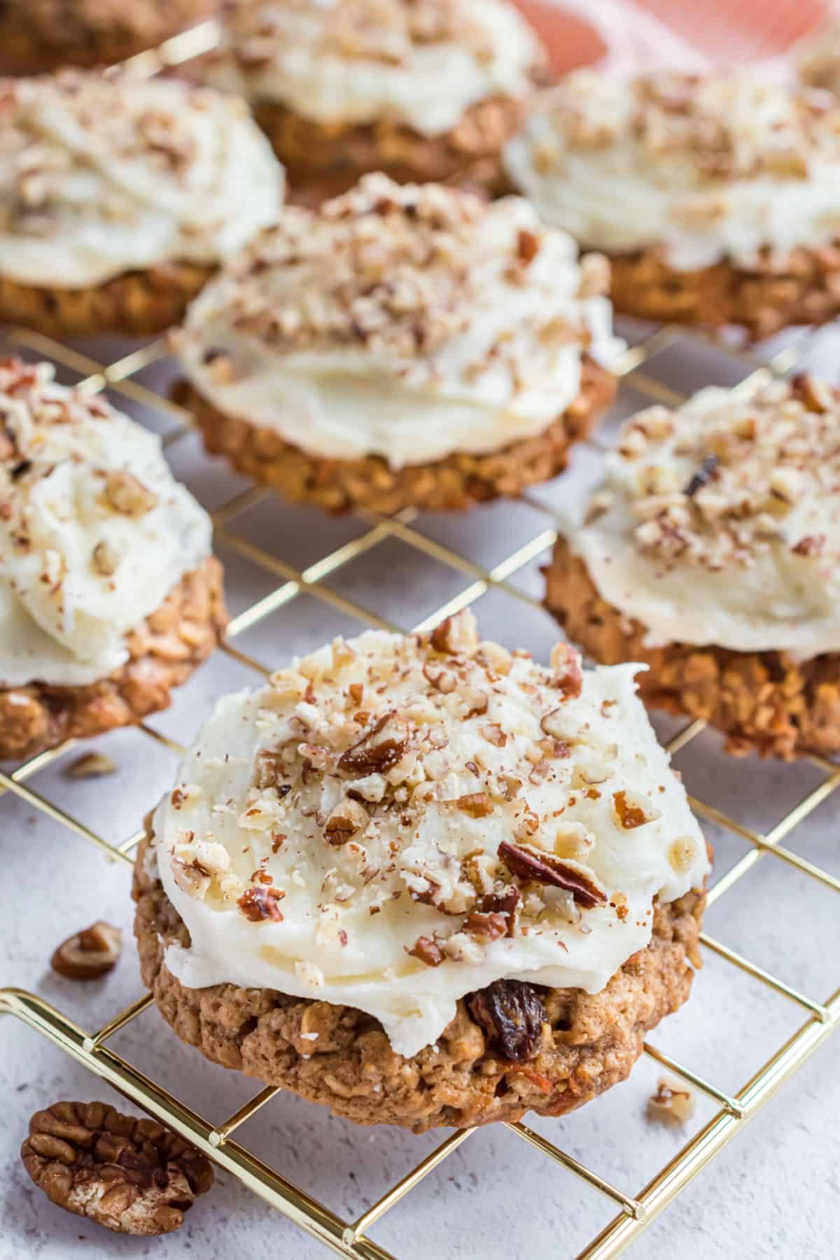 Cream cheese frosted carrot cake cookies on wire rack.