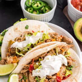 Chicken fajitas on a flour tortilla with sour cream.