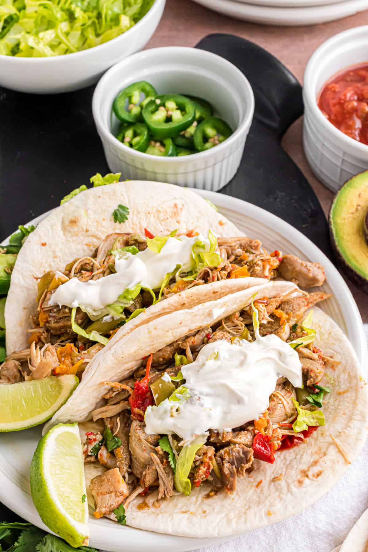 Chicken fajitas on a flour tortilla with sour cream.