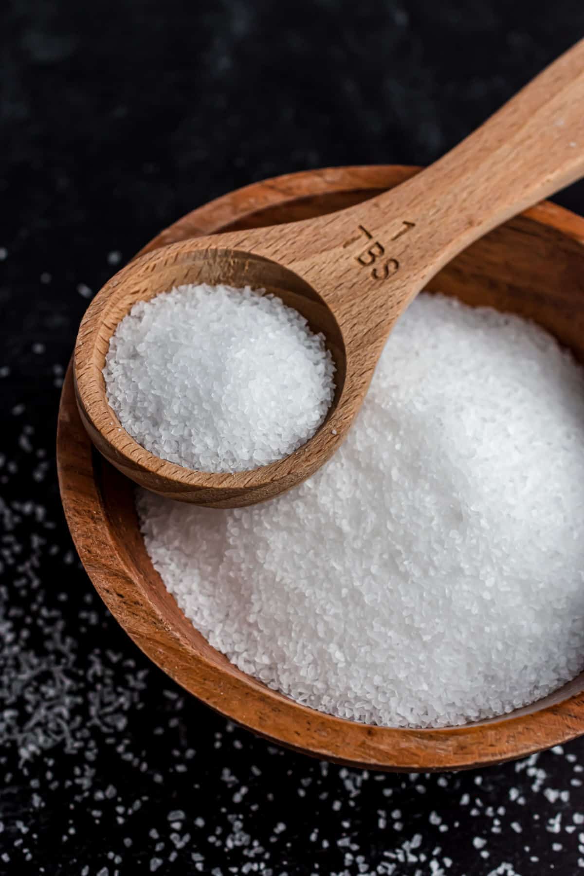 Kosher salt in a wooden bowl with wooden tablespoon.