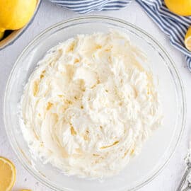Creamy lemon frosting in a clear glass bowl.