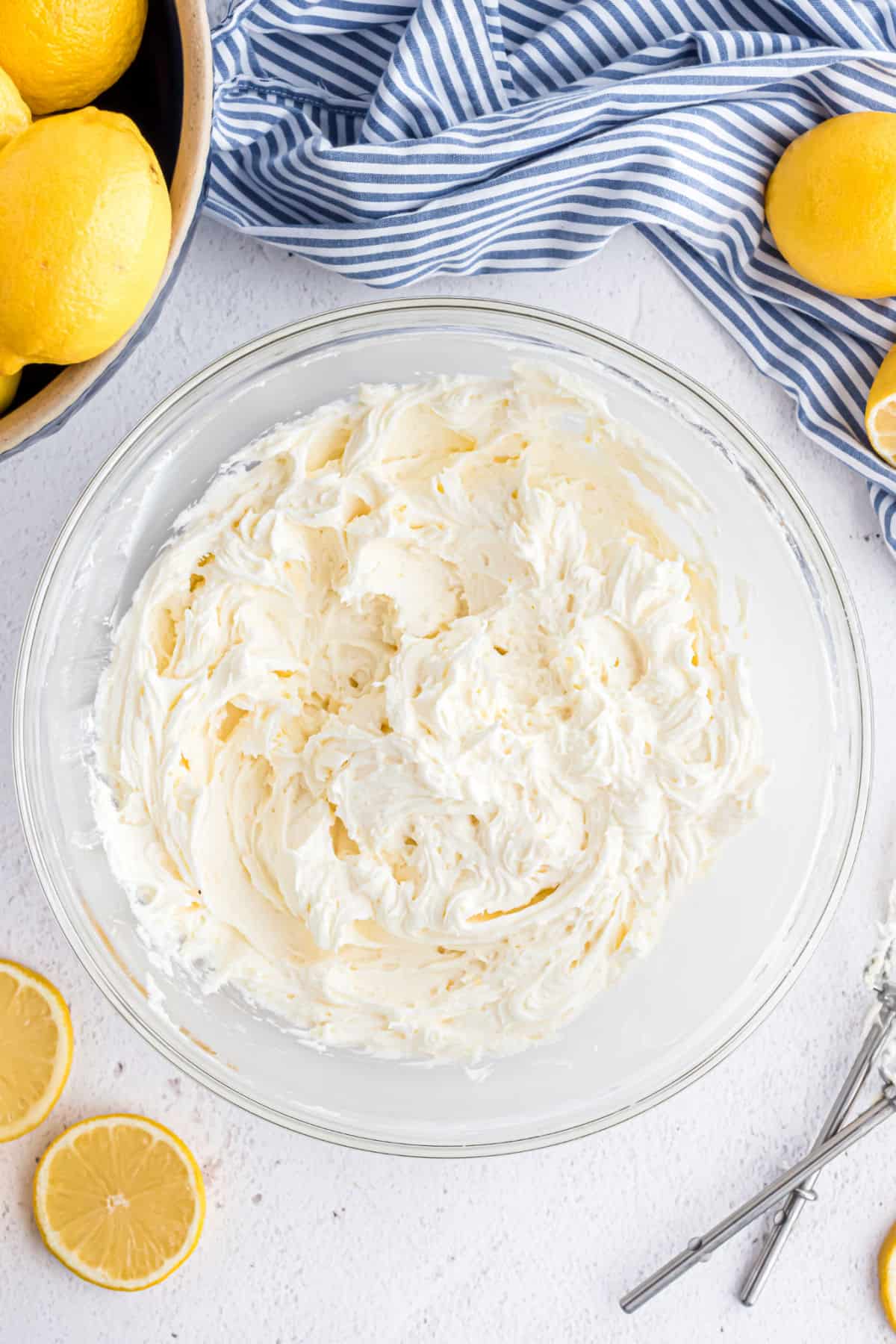 Creamy lemon frosting in a clear glass bowl.