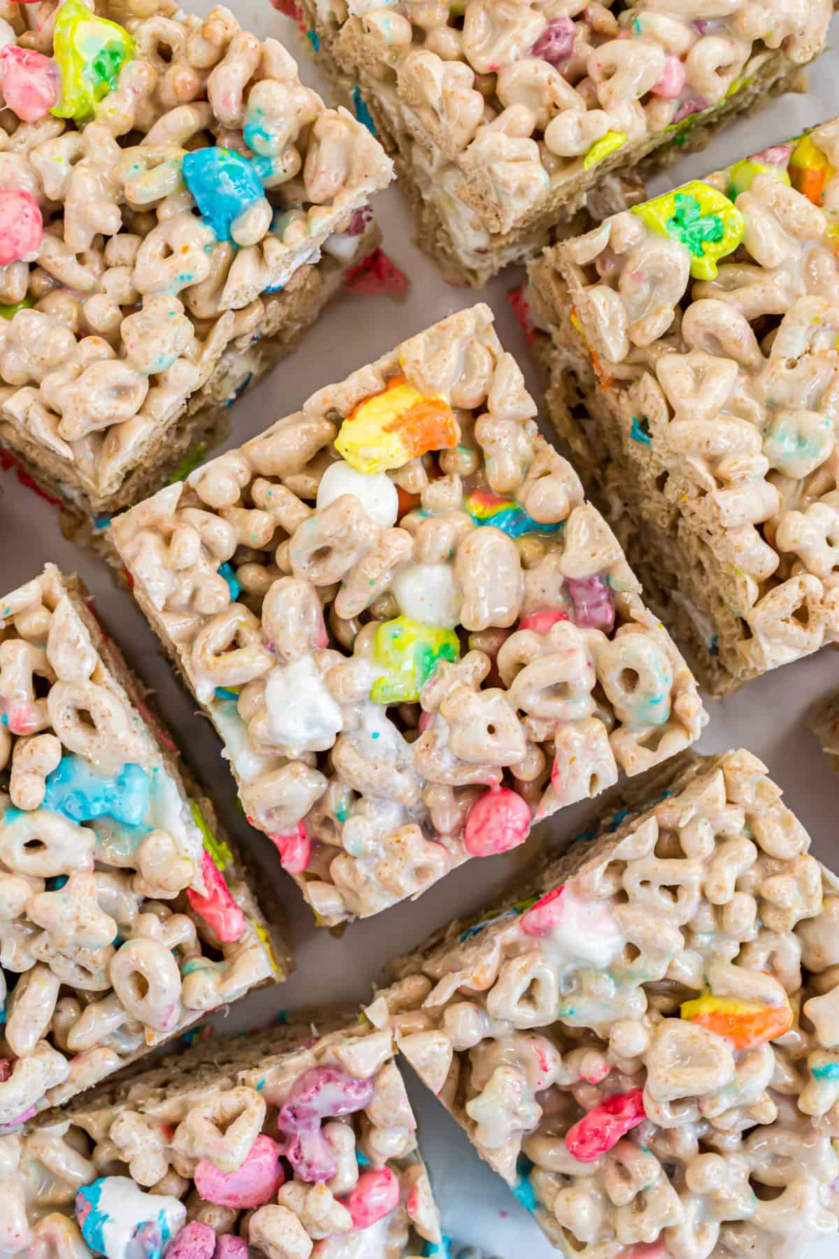 Lucky charms marshmallow treat bars cut into squares on parchment paper.