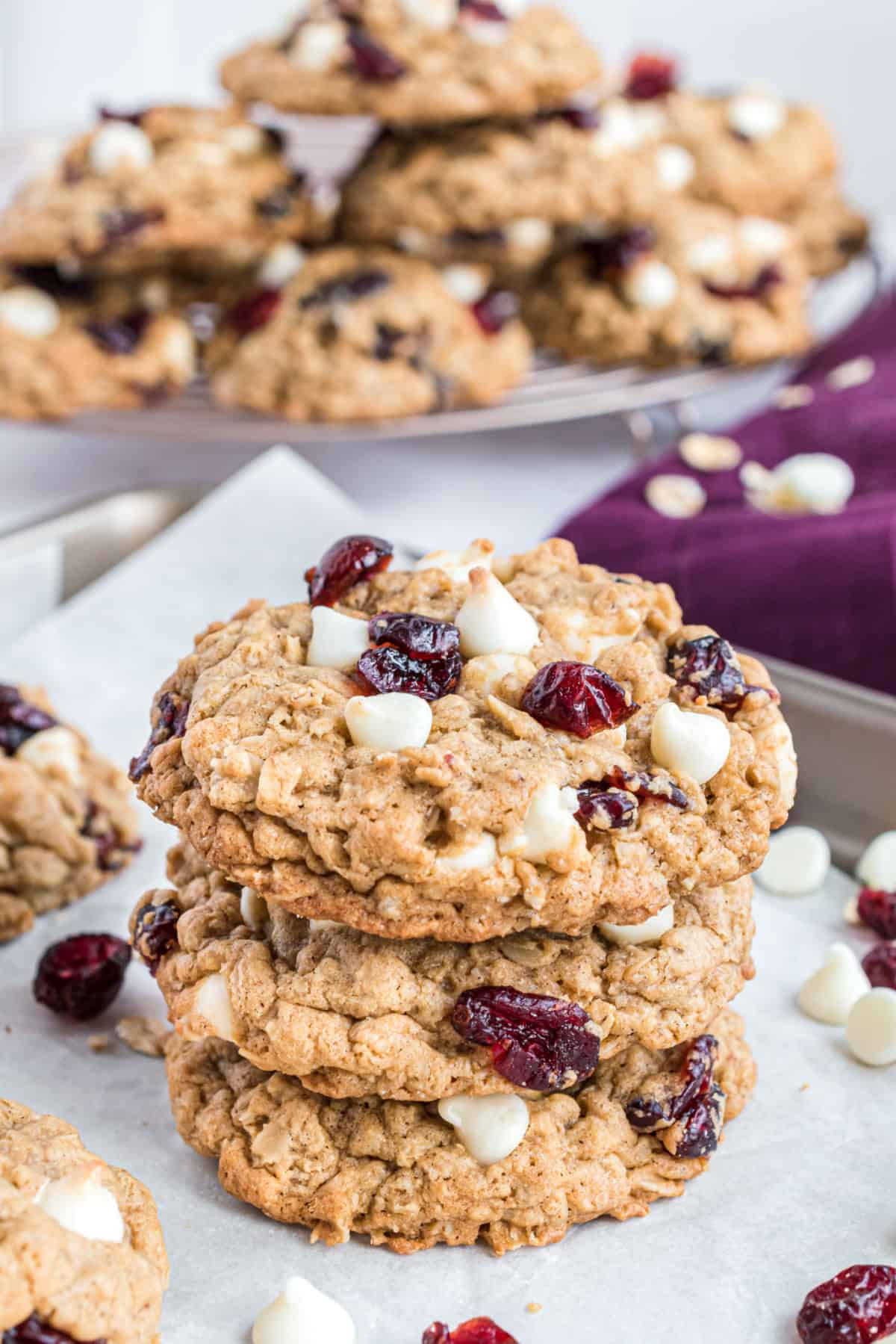 Stack of three oatmeal cookies with white chocolate and craisins.