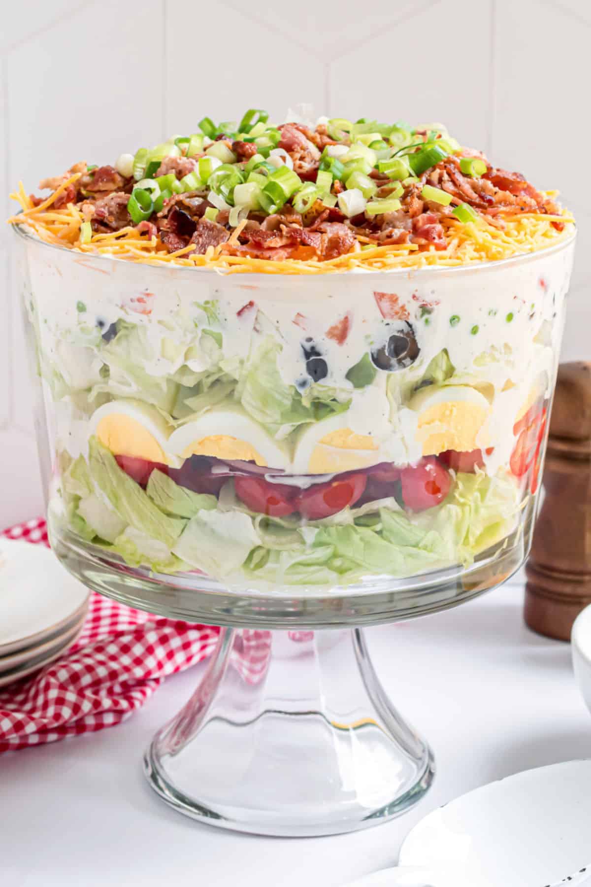 Seven layer salad in a trifle bowl.