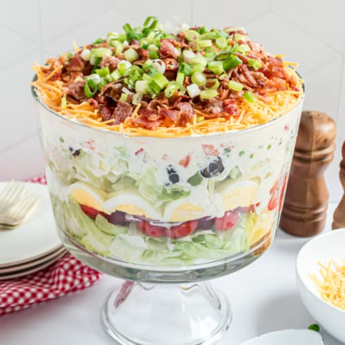 A classic, easy 7 layer Salad recipe served in a trifle bowl. So many options for the seven layers, you choose what you love. Perfect for potlucks!