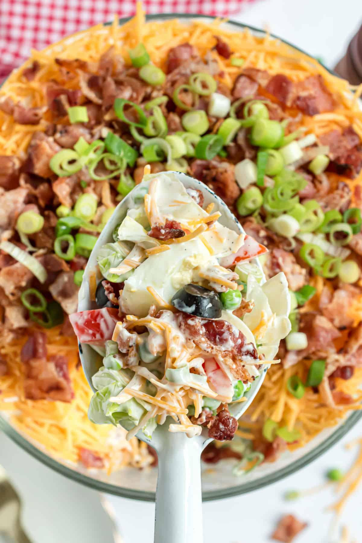 Seven layer salad with a large serving spoon.