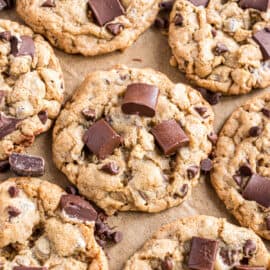 Chocolate chip cookies with chocolate chunks on parchment paper.