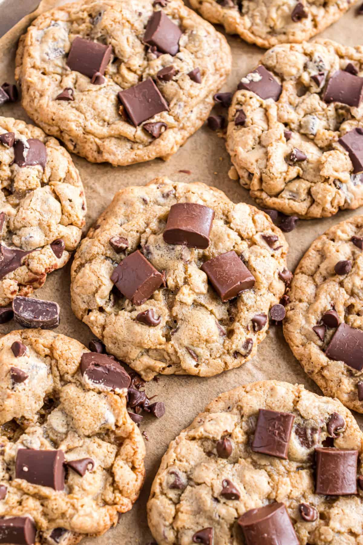 Chocolate chip cookies with chocolate chunks on parchment paper.