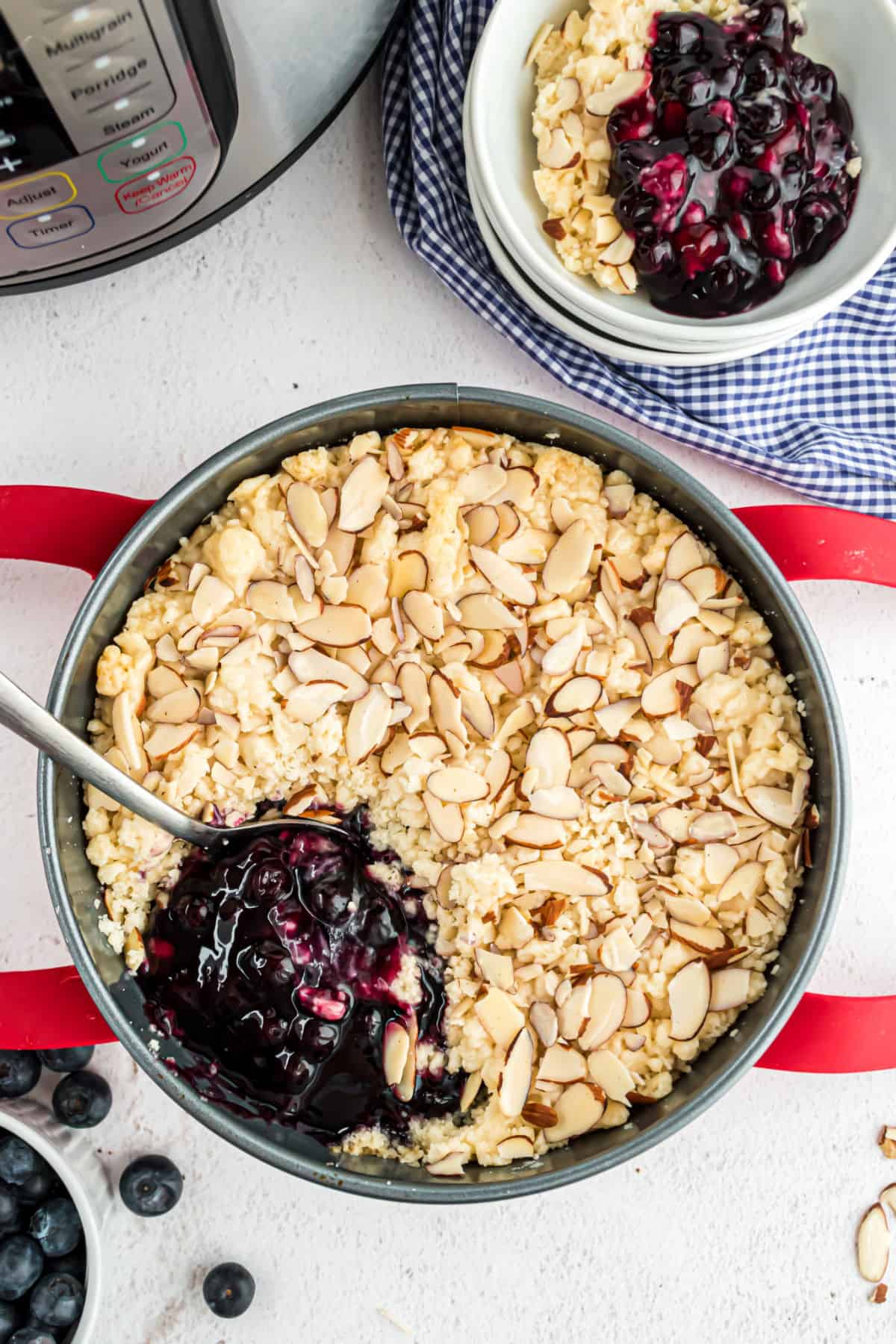 Blueberry cobbler in round cake pan with one scoop removed