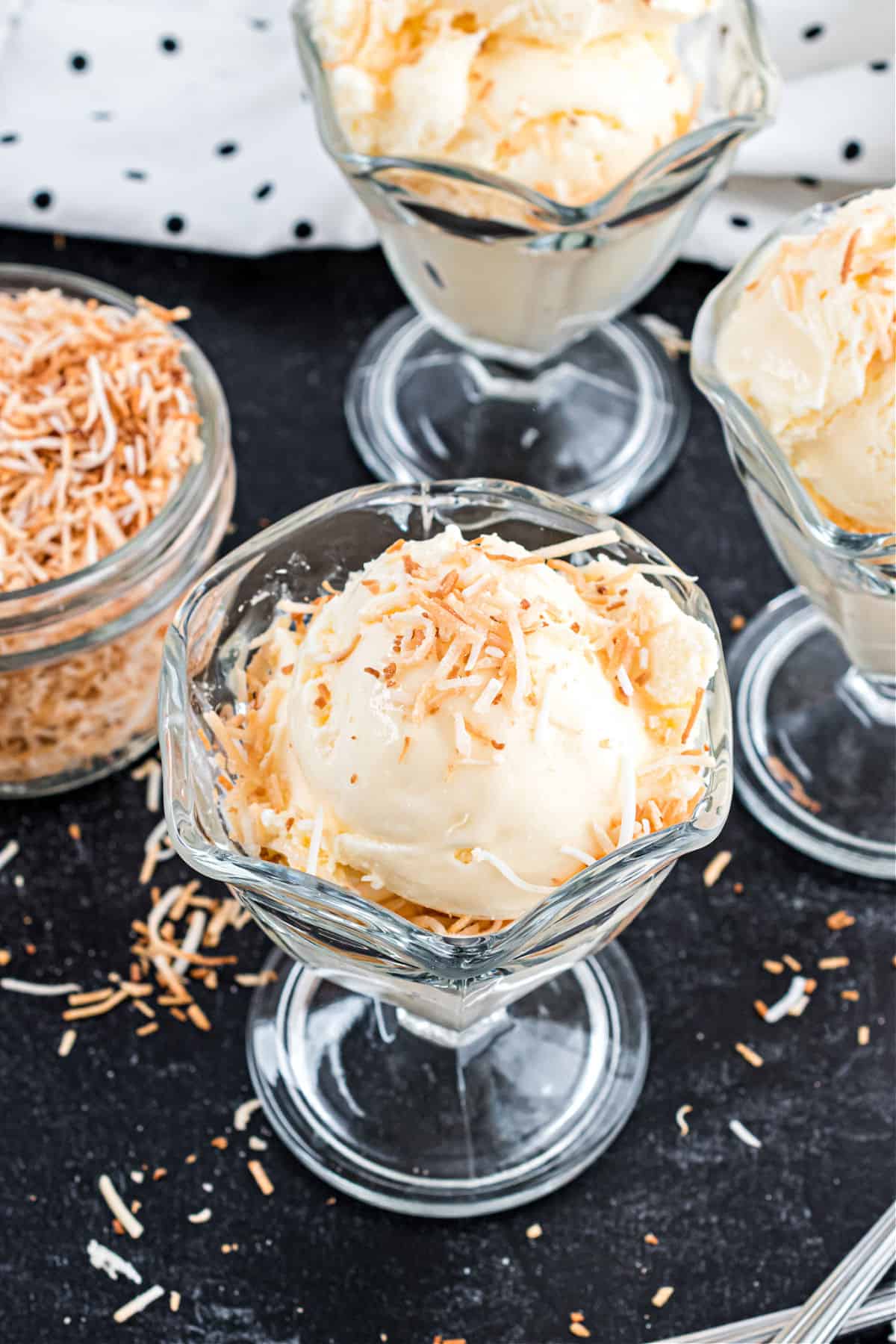 Toasted coconut sprinkled on vanilla ice cream sundaes.