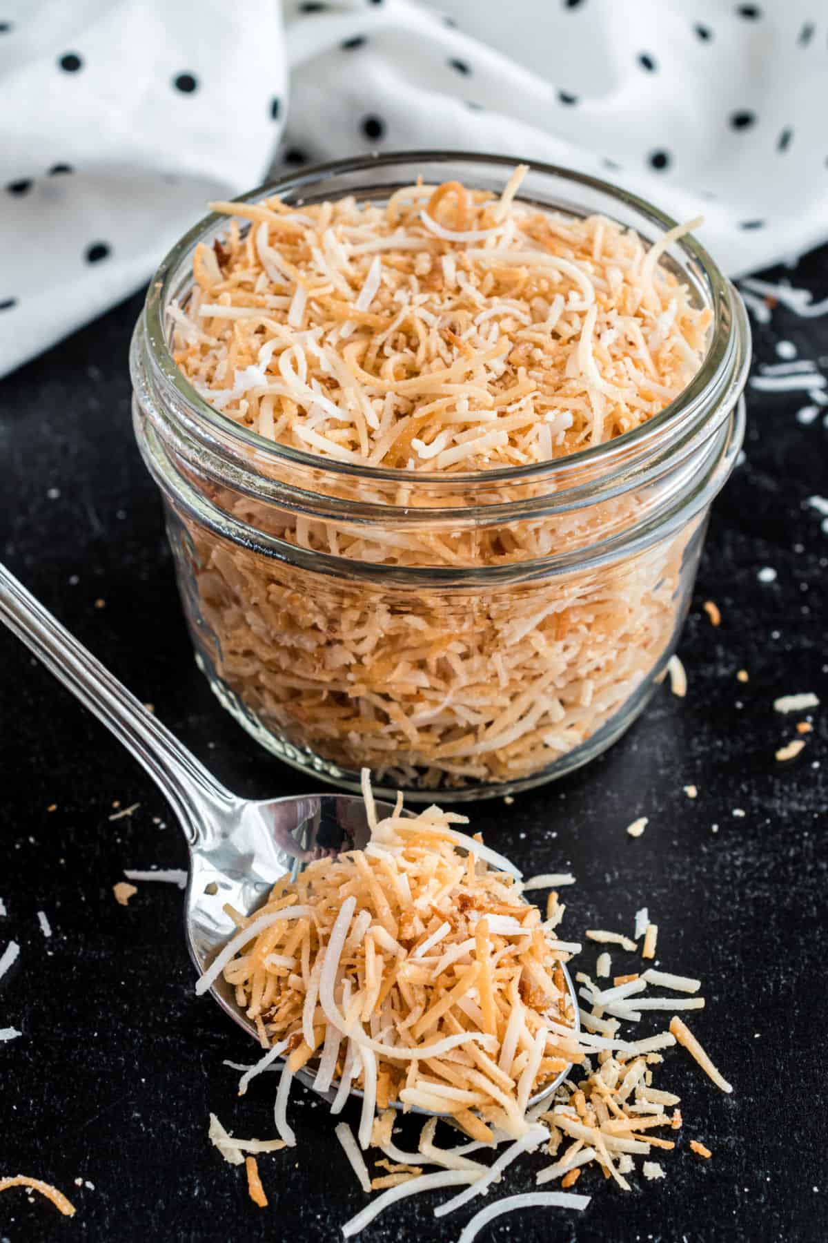 Toasted coconut in a bowl and on a spoon.