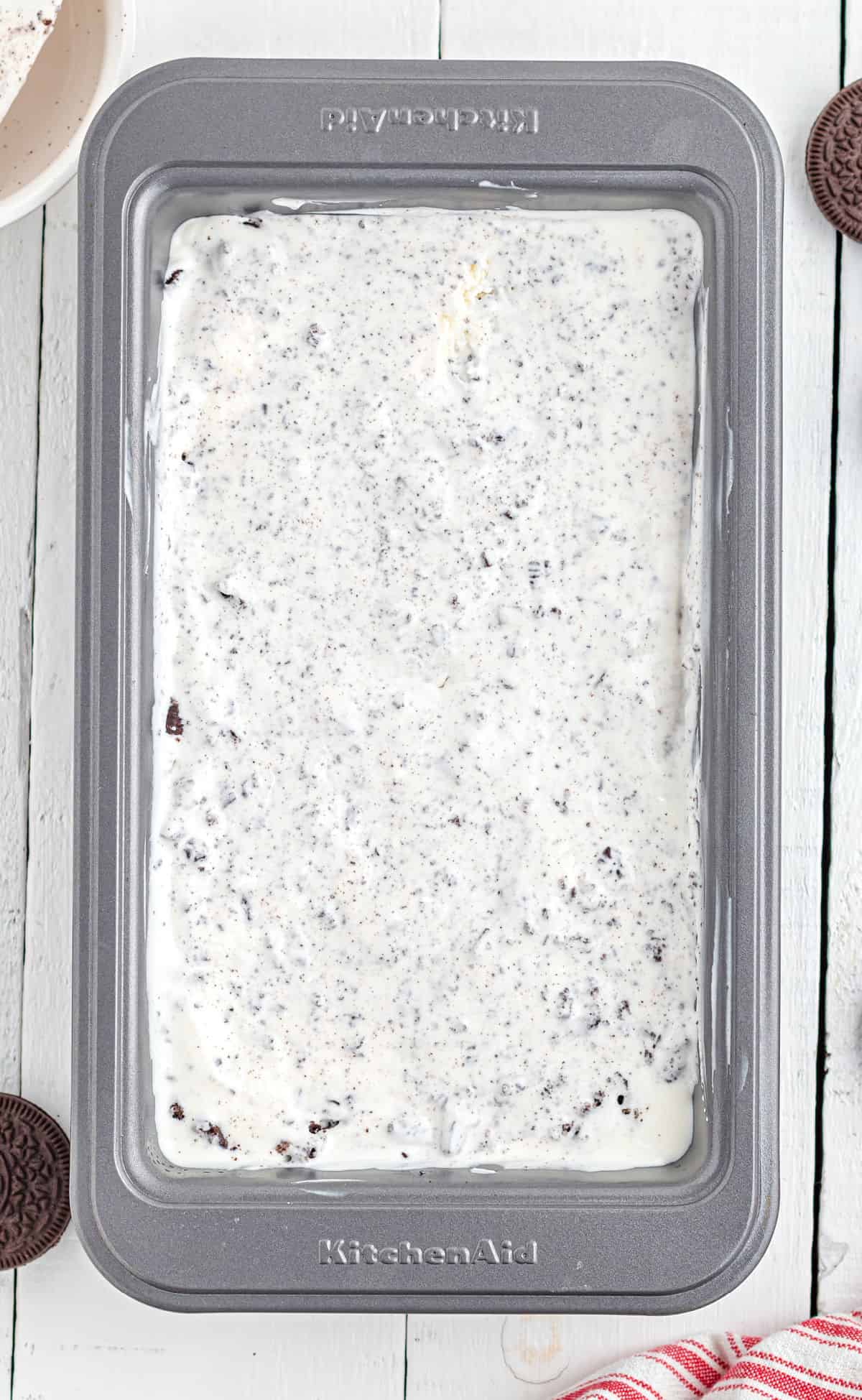 Metal loaf pan with cookies and cream ice cream.