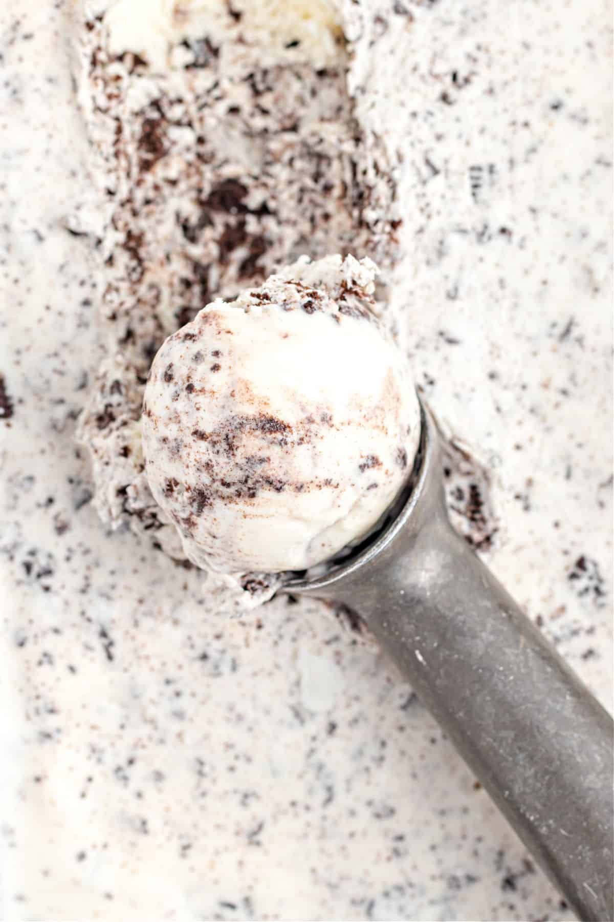Oreo ice cream in metal loaf pan with scooper.