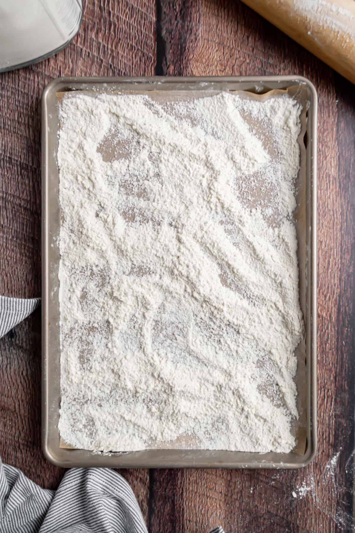 Metal cookie sheet covered with flour to bake.