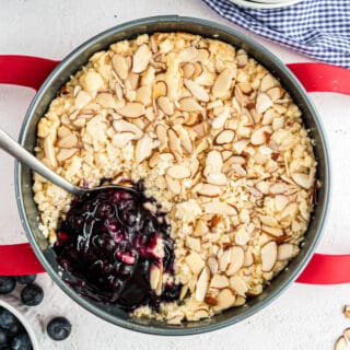 Blueberry cobbler in a springform pan with one scoop removed.