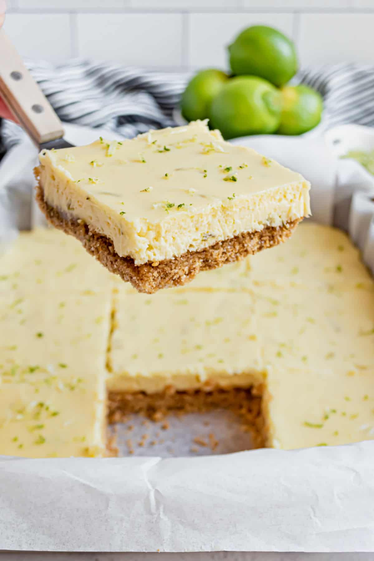 Key lime pie bar on a spatula for serving.