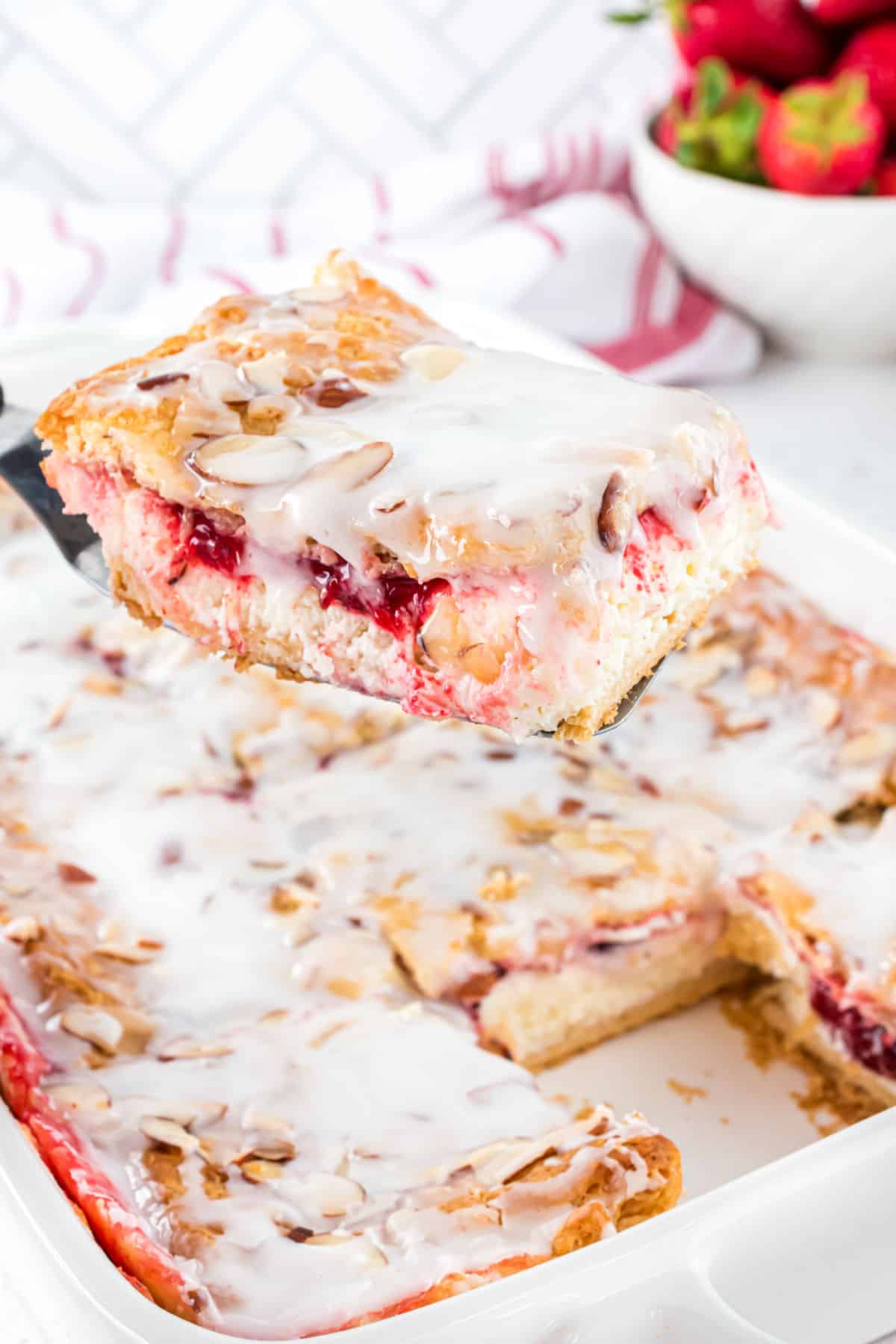 Strawberry cheesecake danish lifted out of the baking dish.