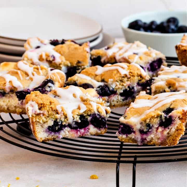 Blueberry sugar cookie bars with cheesecake filling on wire rack.