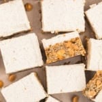 Frosted oatmeal scotchie bars with butterscotch chips, arranged in neat squares on parchment paper.