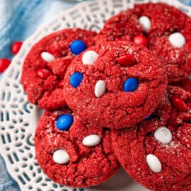 Red velvet cookies stacked on a white plate.