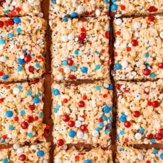 Rice krispy treats cut into squares and decored with red white and blue sprinkles.