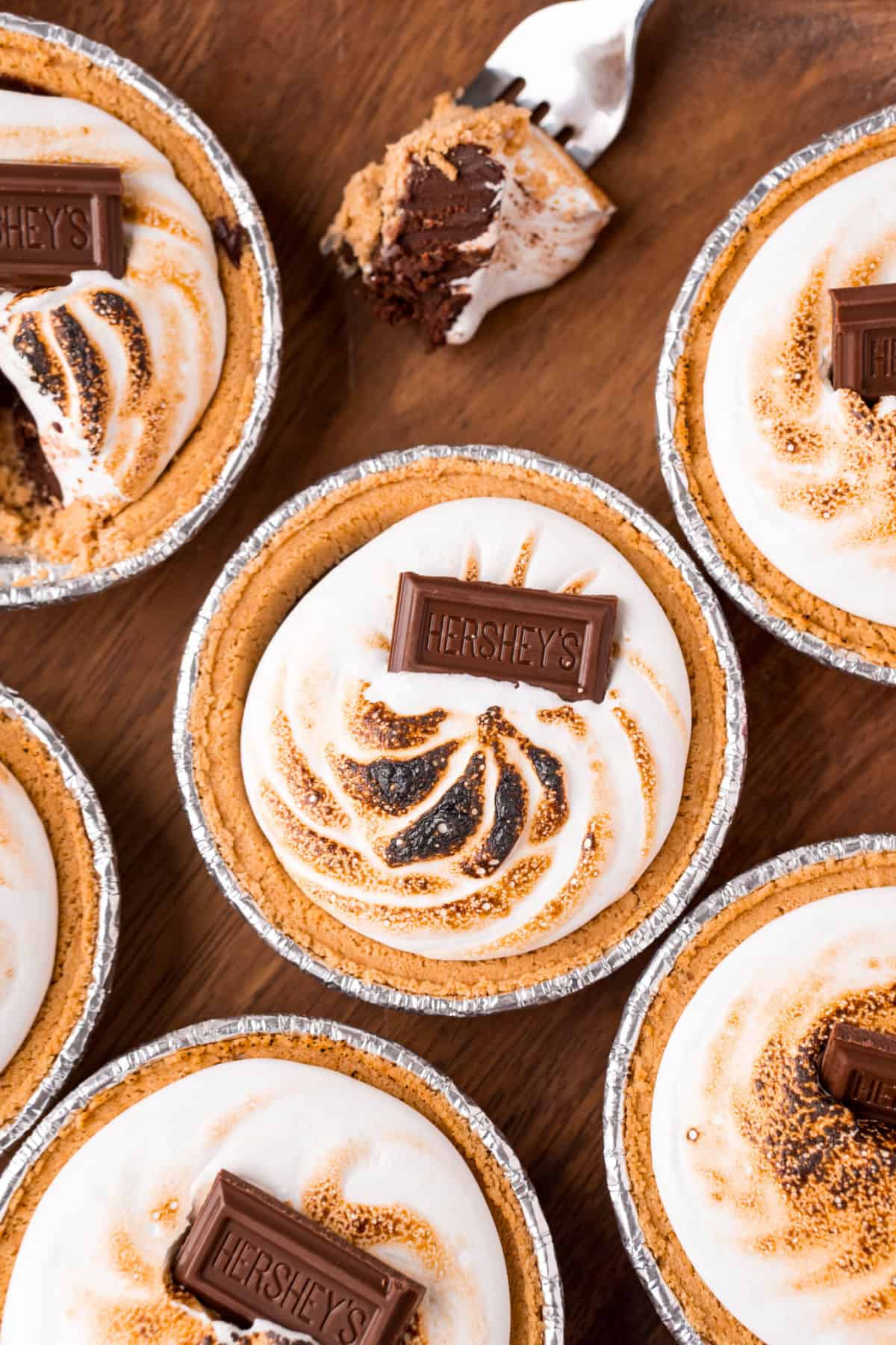 Mini s'mores pies with toasted marshmallow and chocolate bars on top.