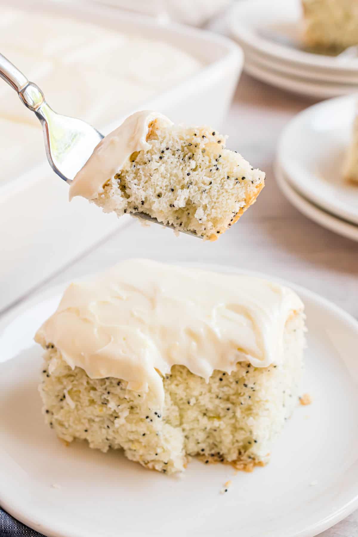 Forkful of lemon cake being taken from slice.