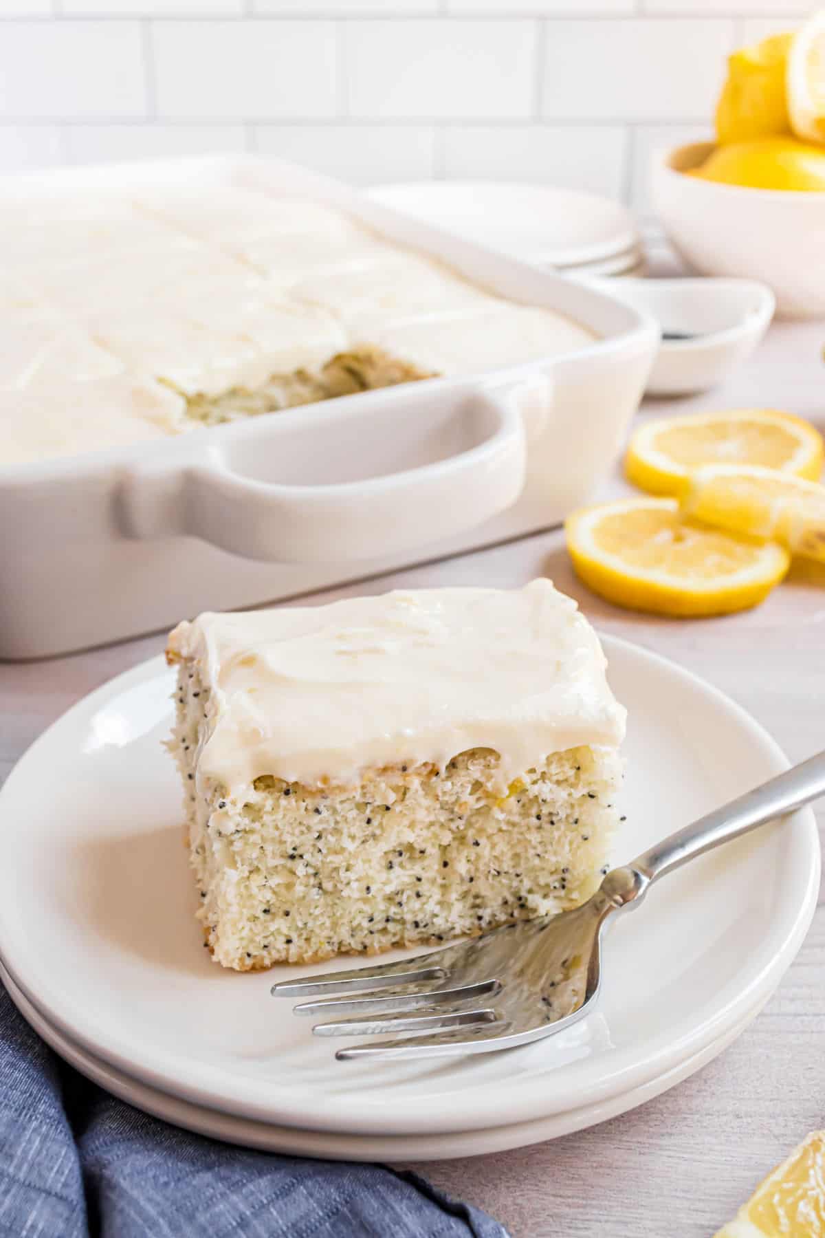 Slice of lemon poppy seed cake on a white plate.