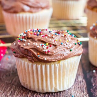 Chocolate frosted yellow cupcake with sprinkles.